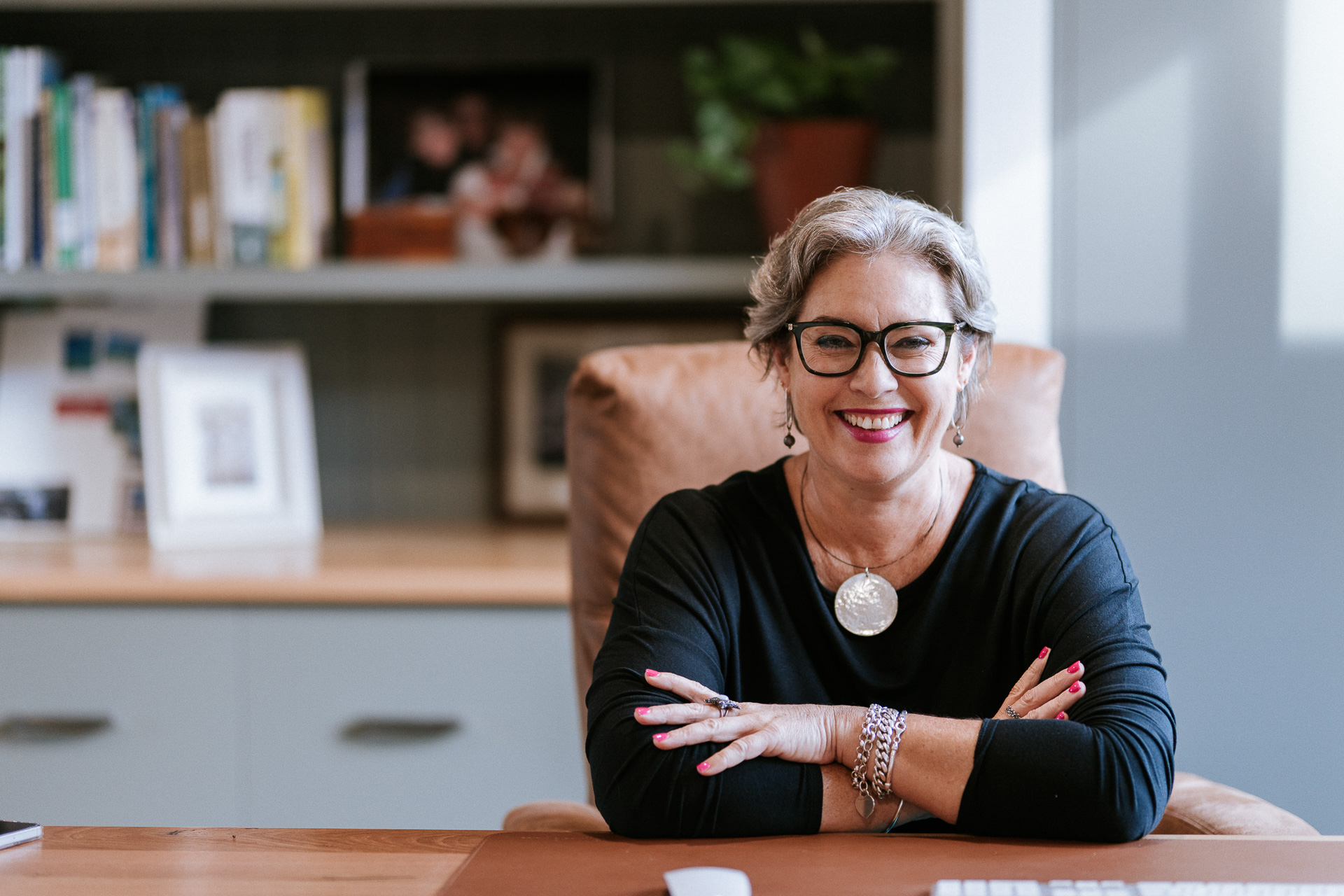 Melissa Meagher, financial wellness coach, smiling warmly at her desk