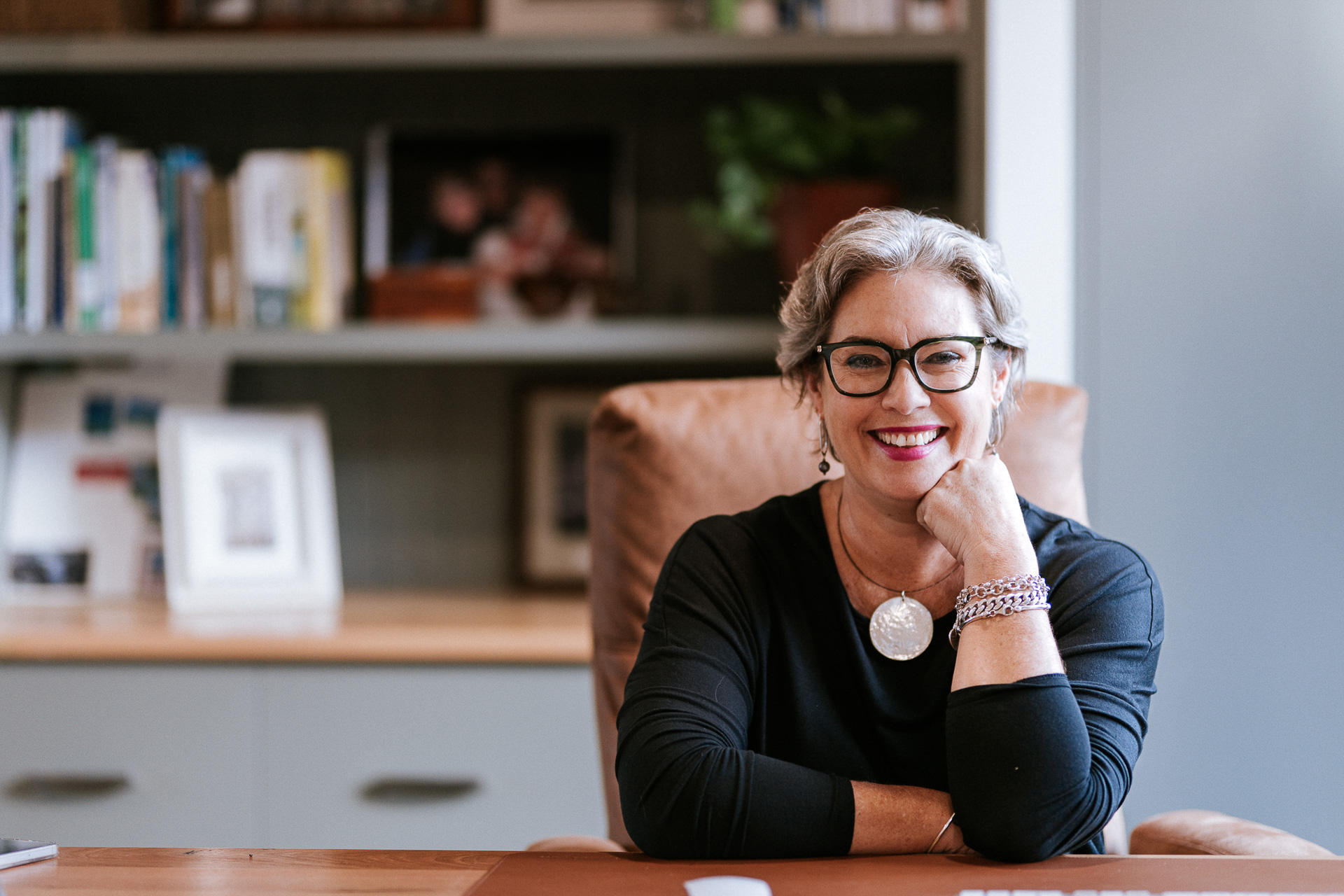 Melissa Meagher, financial wellness coach, smiling warmly at her desk